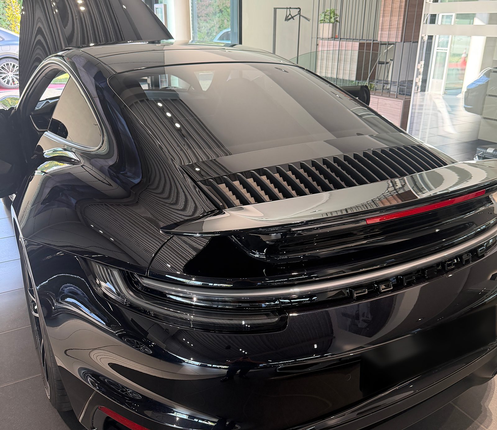 Záď skutečného Porsche 911 Turbo S CK EUKA s aktivním zadním křídlem a světelným pruhem